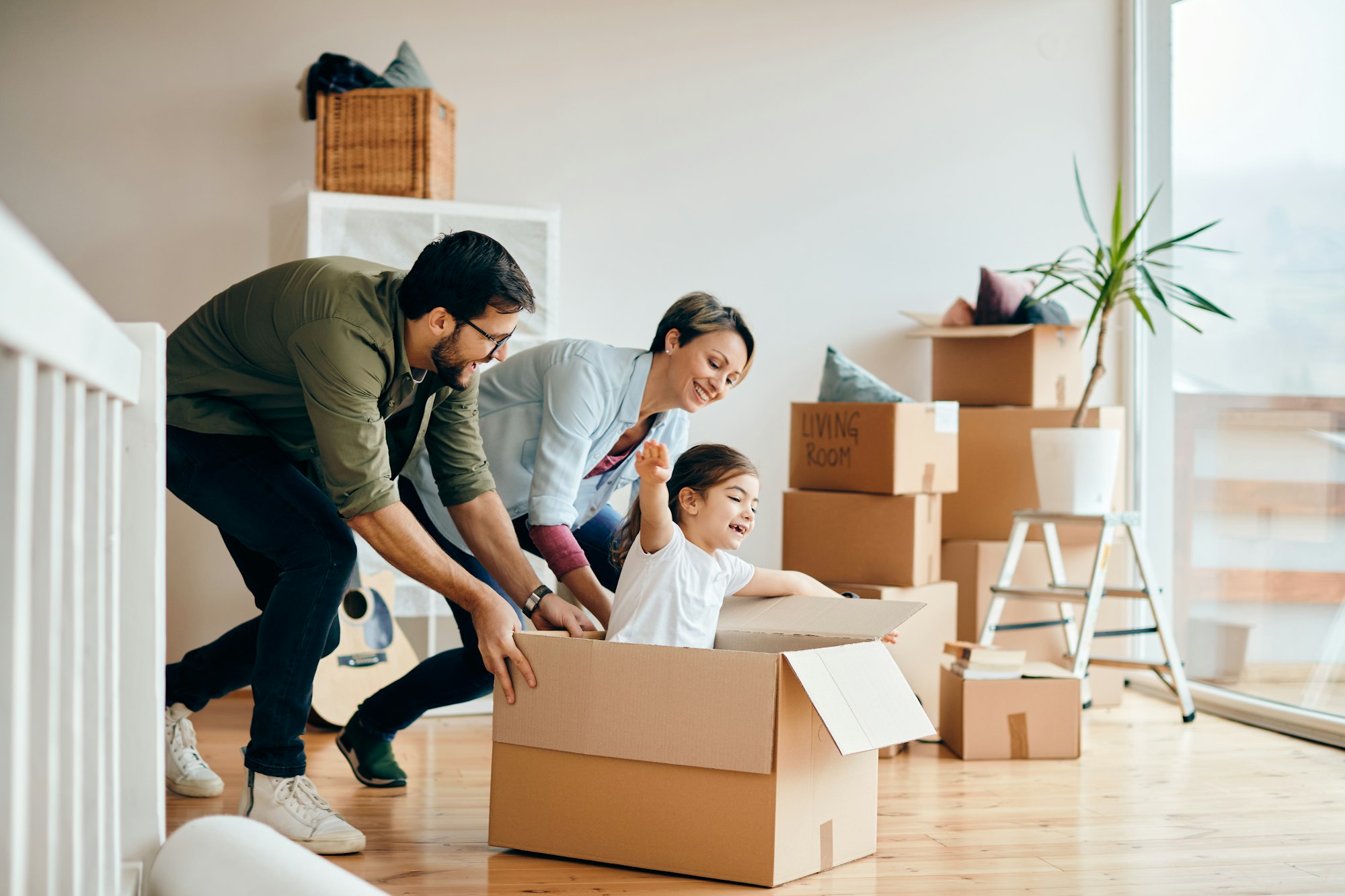 Famiglia giocosa che si diverte durante il trasloco nella nuova casa.
