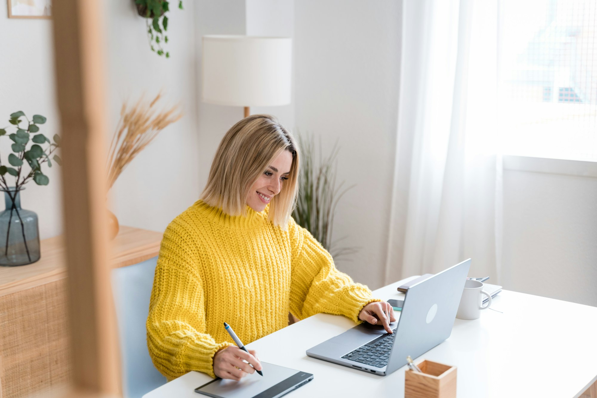 Donna concentrata che lavora al laptop a casa