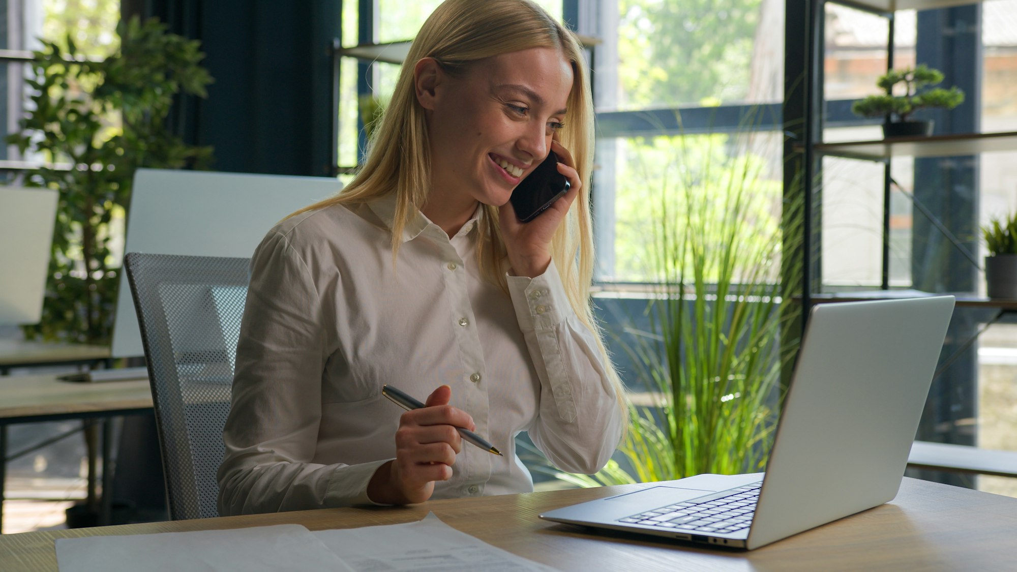 Happy Caucasian businesswoman talk phone conversation consult client business commerce in office